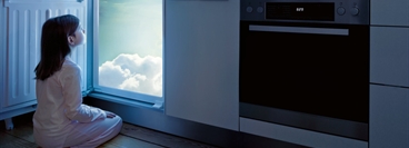 Photo composition with a child in front of a refrigerator, looking into clouds